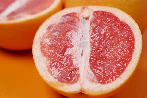 Close-up de uma fatia de fruta laranja na cor de fundo