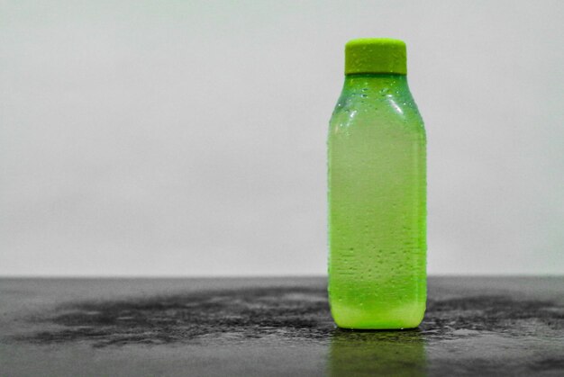 Foto close-up de uma garrafa verde na mesa