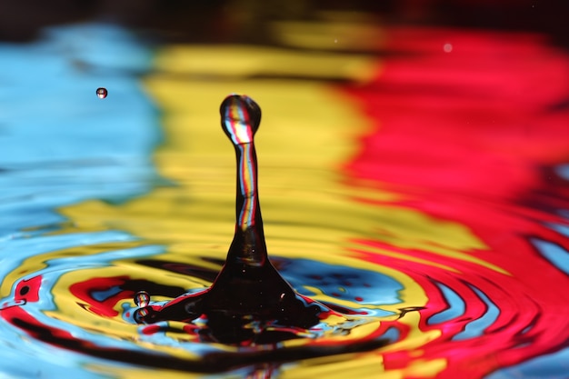 Foto close-up de uma gota d'água caindo e impacto com um corpo d'água