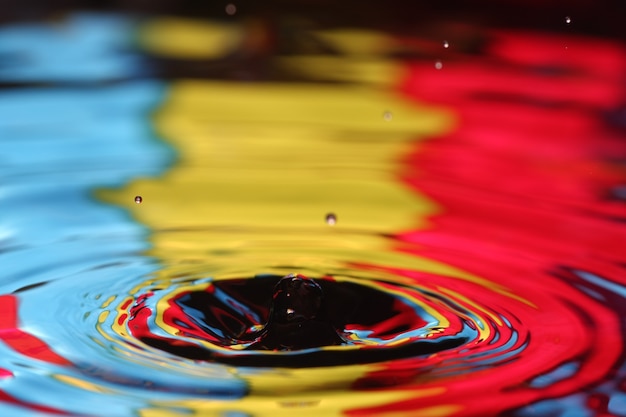 Foto close-up de uma gota d'água caindo e impacto com um corpo d'água