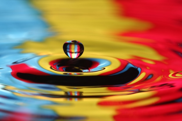 Foto close-up de uma gota d'água caindo e impacto com um corpo d'água