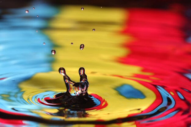 close-up de uma gota d'água caindo e impacto com um corpo d'água