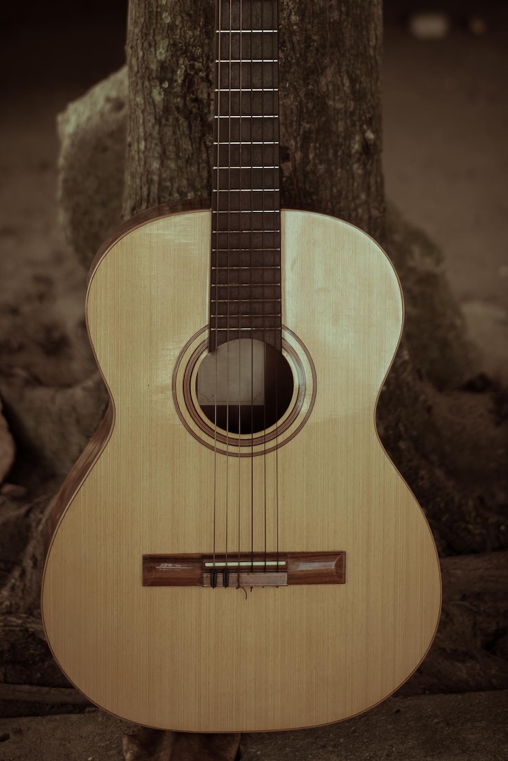 Foto close-up de uma guitarra no tronco de uma árvore