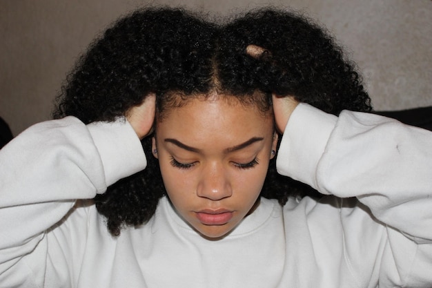 Close-up de uma jovem com a mão no cabelo encaracolado