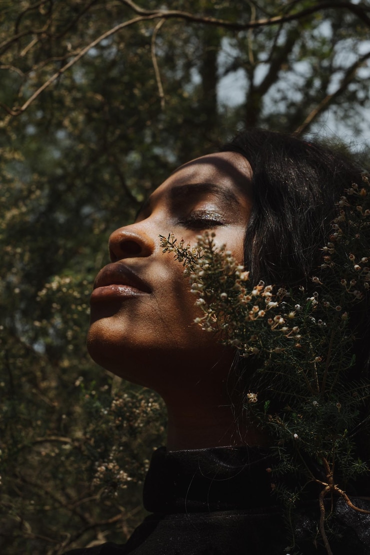 Foto close-up de uma jovem com os olhos fechados por plantas.