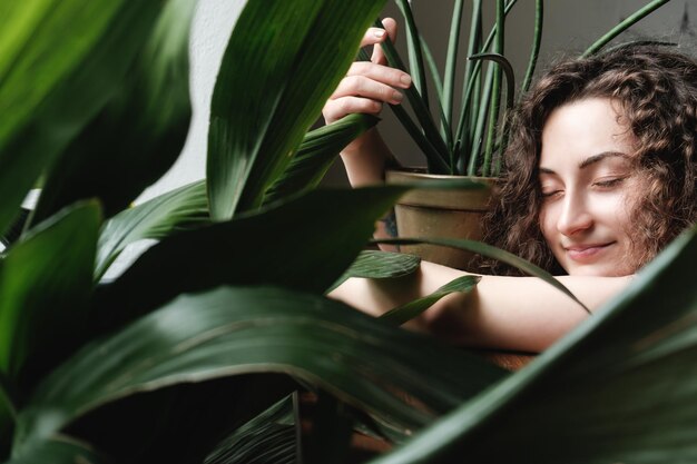 Foto close-up de uma jovem com plantas em vaso em casa