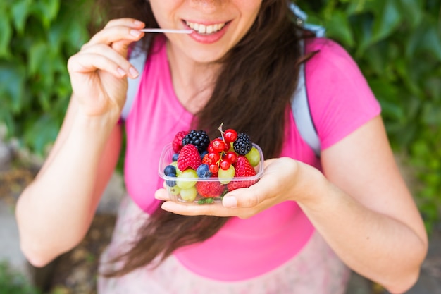 Close-up de uma jovem feliz com frutas frescas