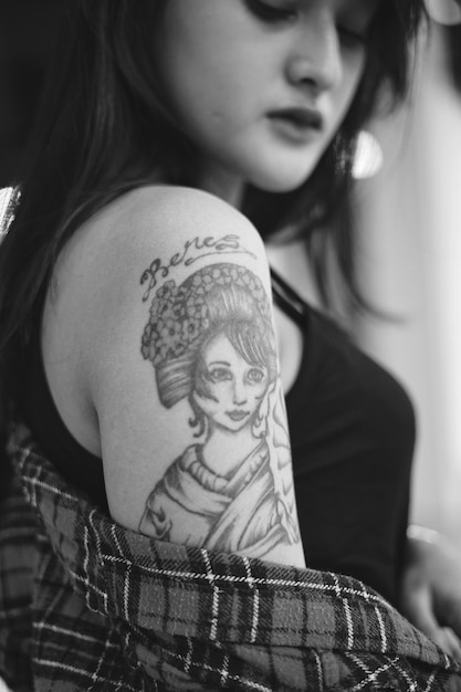 Close-up de uma jovem mostrando uma tatuagem