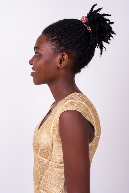 Close-up de uma jovem mulher africana com um vestido dourado pronto para a festa, isolada