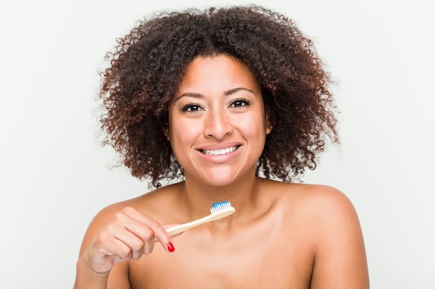 Close-up de uma jovem mulher afro-americana, escovar os dentes com uma escova de dentes