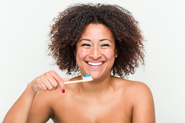 Foto close-up de uma jovem mulher afro-americana, escovar os dentes com uma escova de dentes