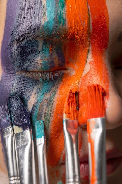 Close-up de uma jovem mulher pintando o rosto