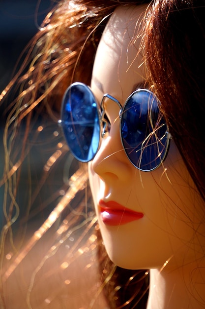 Foto close-up de uma jovem usando óculos de sol