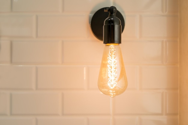Foto close-up de uma lâmpada iluminada contra a parede