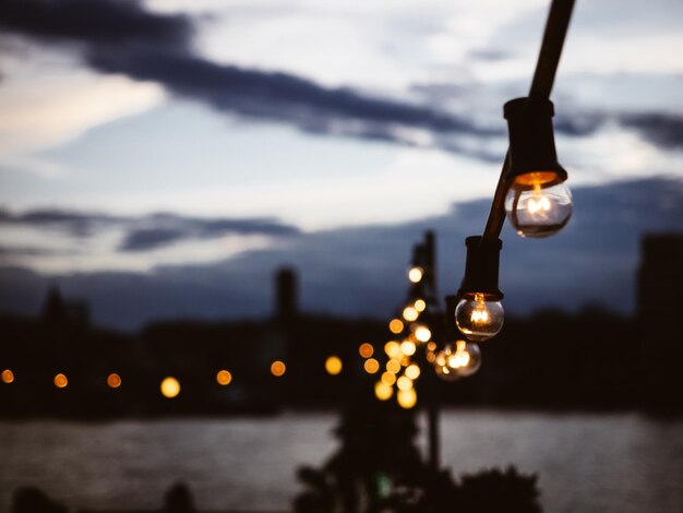 Foto close-up de uma lâmpada iluminada sobre o lago contra o céu