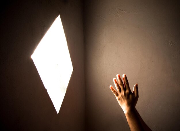 Close-up de uma mão orando segurando uma luz iluminada