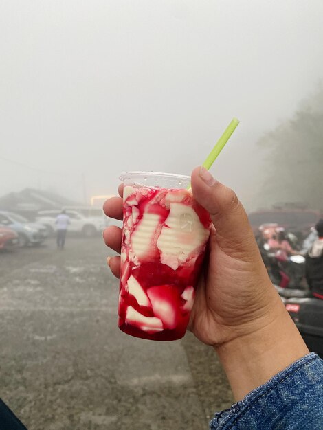 Foto close-up de uma mão segurando um cone de sorvete