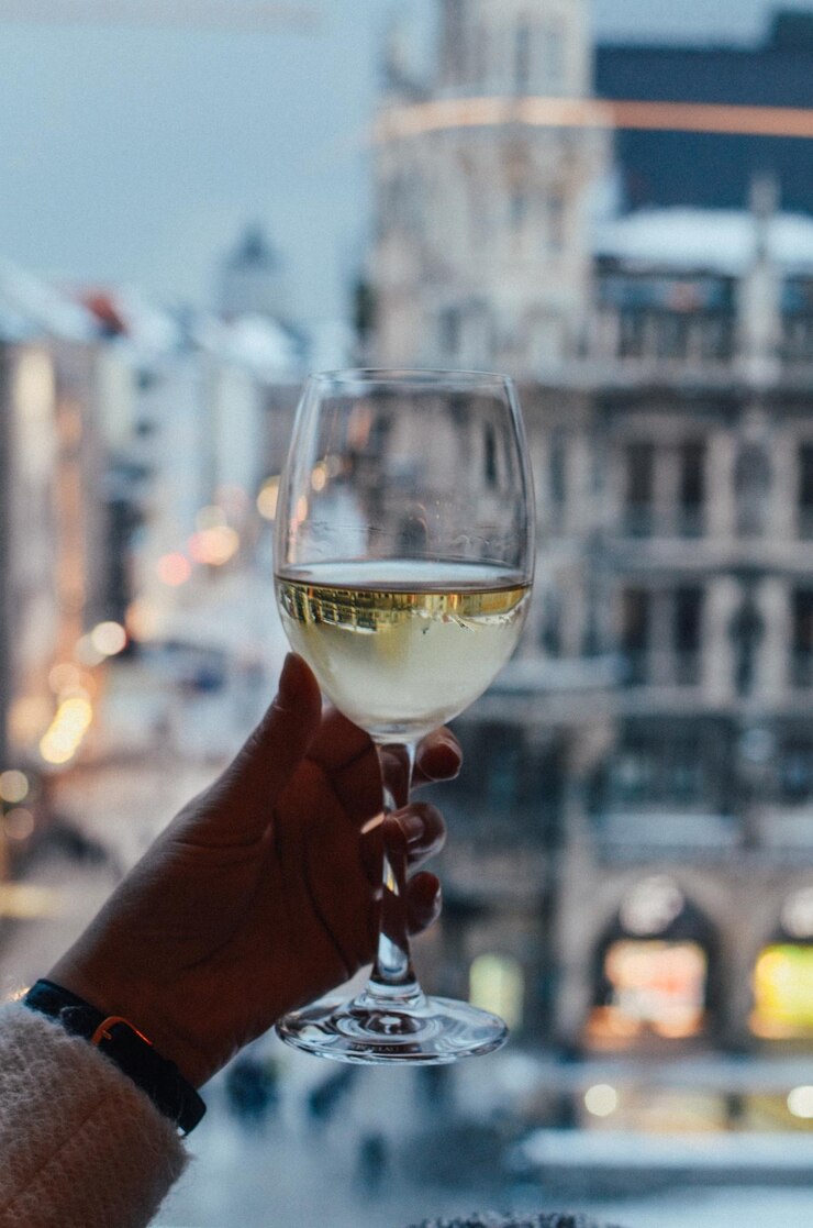 Foto close-up de uma mão segurando um copo de vinho