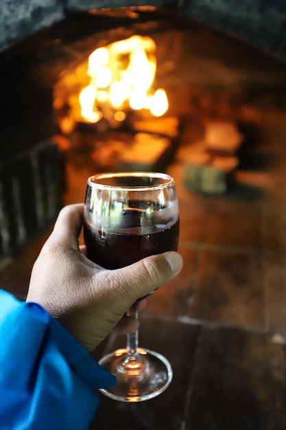 Foto close-up de uma mão segurando um copo de vinho