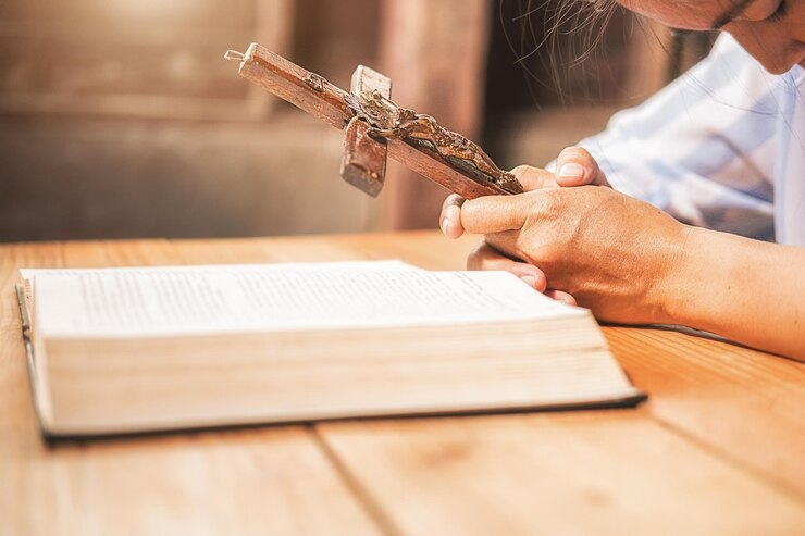 Foto close-up de uma mão segurando um livro na mesa