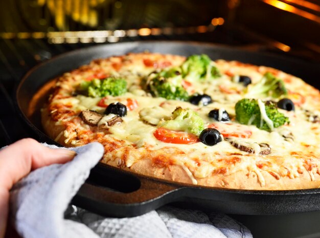 Close-up de uma mão segurando uma pizza