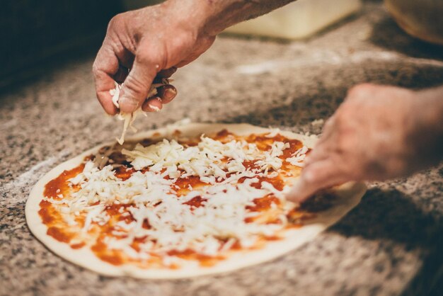 Foto close-up de uma mão segurando uma pizza