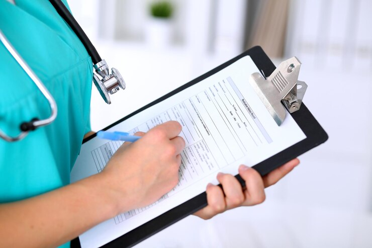 Foto close-up de uma médica está preenchendo o formulário de inscrição ou histórico médico