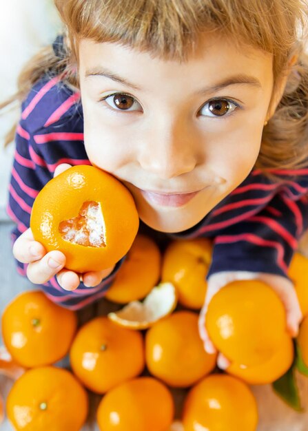 Foto close-up de uma menina bonita segurando uma laranja