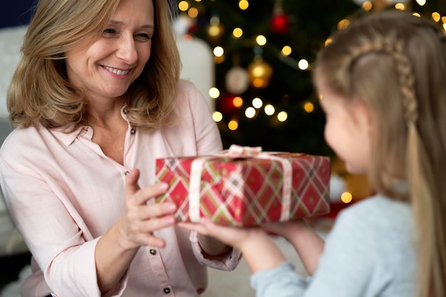 Close-up de uma menina dando um presente de Natal para sua avó