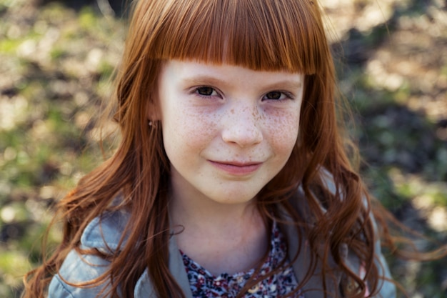 Close-up de uma menina ruiva feliz ao ar livre