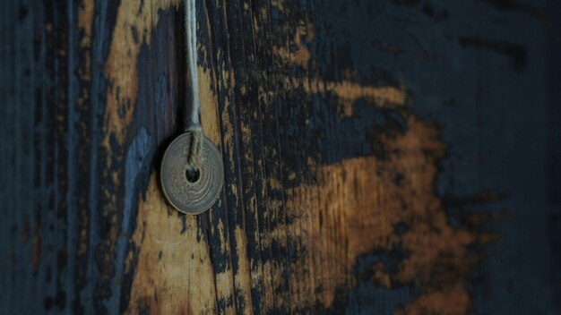 Foto close-up de uma moeda pendurada em madeira