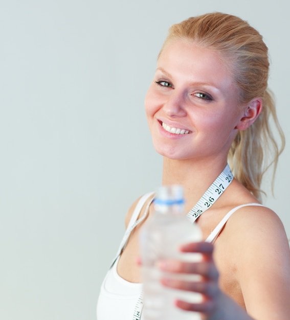 Close-up de uma mulher feliz segurando uma garrafa de água foco na mulher