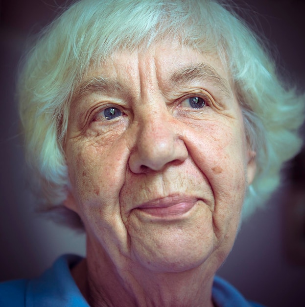 Close-up de uma mulher idosa pensativa olhando para longe