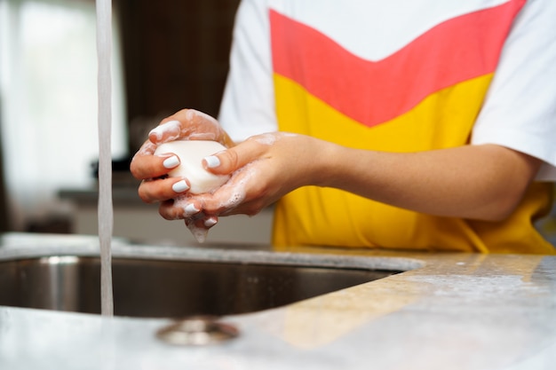 Foto close-up de uma mulher lavando as mãos em uma pia de cozinha