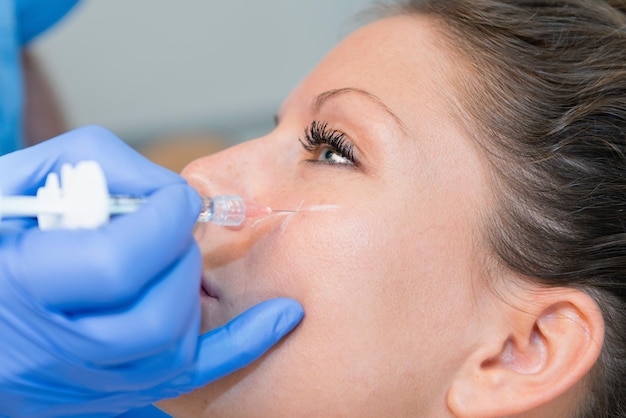Close-up de uma mulher recebendo injeção de hialuronana no rosto