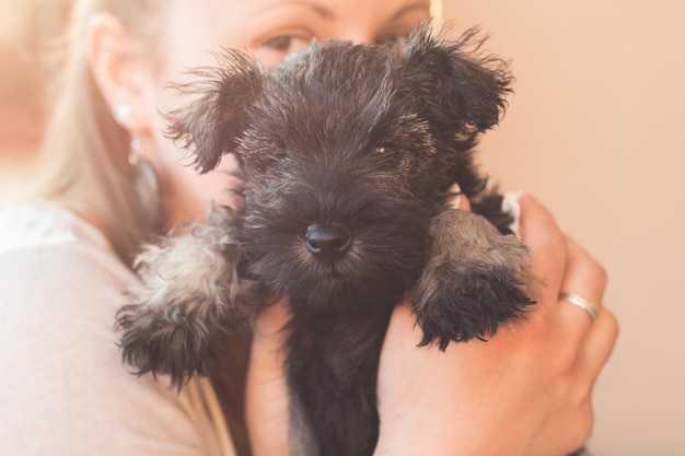 Close-up de uma mulher segurando um cachorrinho preto