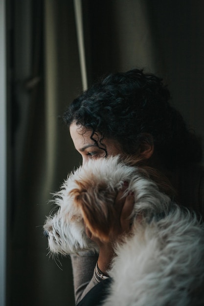 Close-up de uma mulher segurando um cachorro em casa