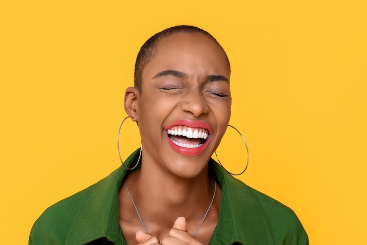 Foto close-up de uma mulher sorridente de pé contra um fundo amarelo