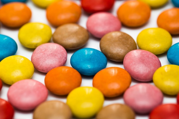 Close up de uma pilha de bombons revestidos de chocolate coloridos, padrão de chocolate, fundo de chocolate