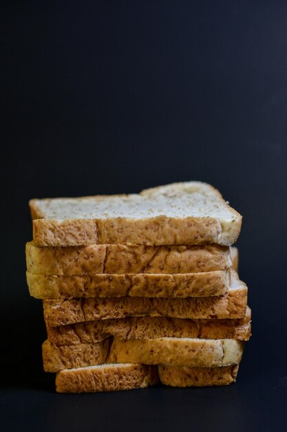 Foto close-up de uma pilha de pão contra um fundo preto