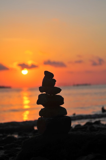 Foto close-up de uma pilha de seixos na praia durante o pôr-do-sol