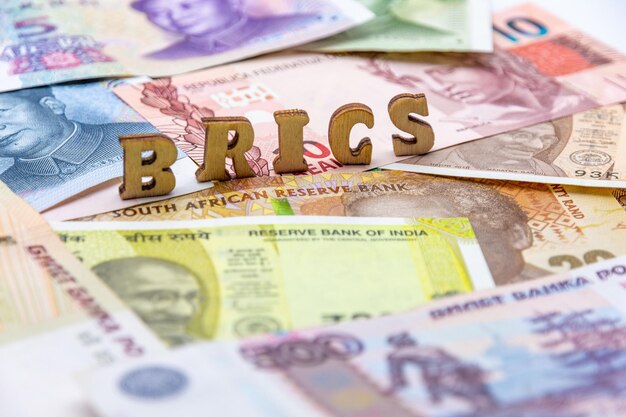 Foto close-up de uma pilha de várias notas de moeda com as letras brics em cima