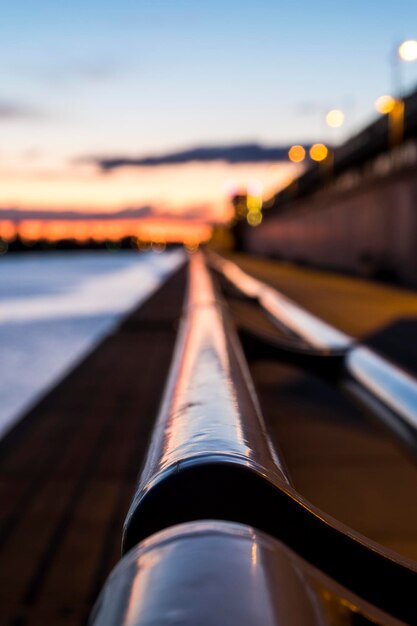 Foto close-up de uma ponte iluminada contra o céu durante o pôr-do-sol