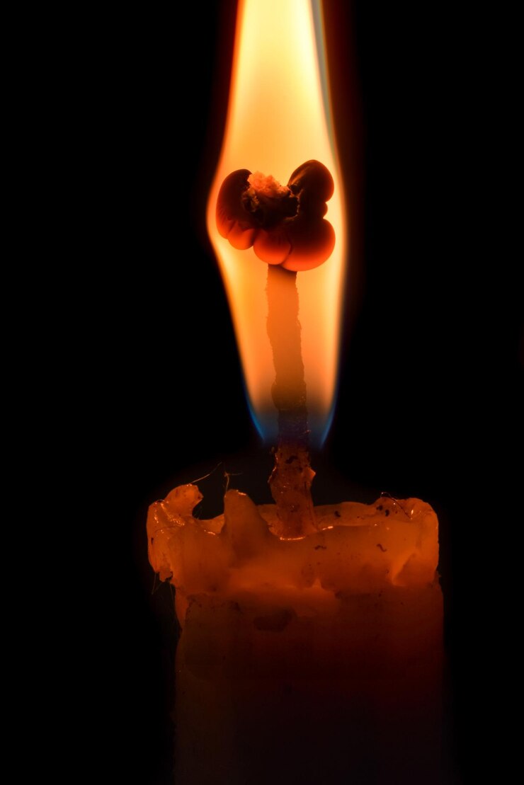 Foto close-up de vela ardente contra fundo preto