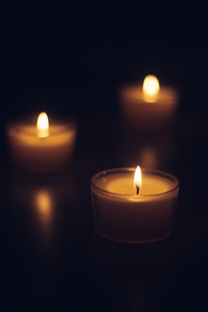 Close-up de velas de chá queimando na câmara escura