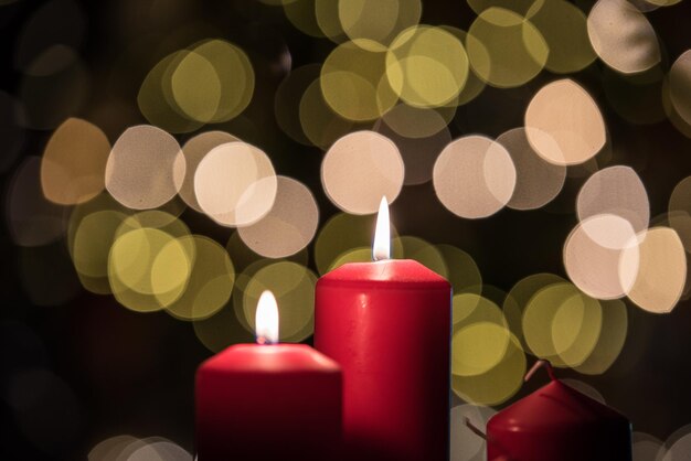 Foto close-up de velas iluminadas contra as luzes de natal