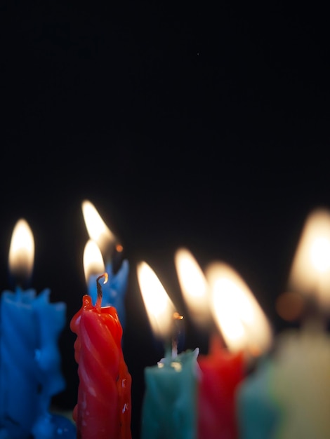 Close-up de velas iluminadas contra fundo preto