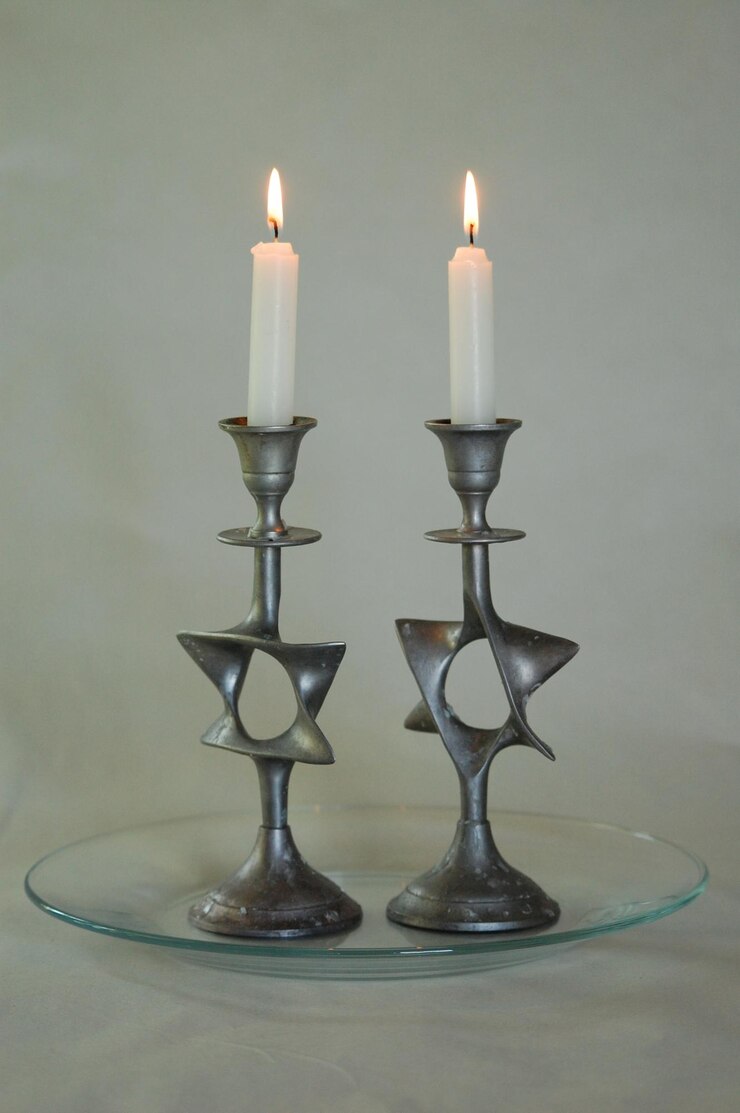 Foto close-up de velas iluminadas em suportes contra fundo branco
