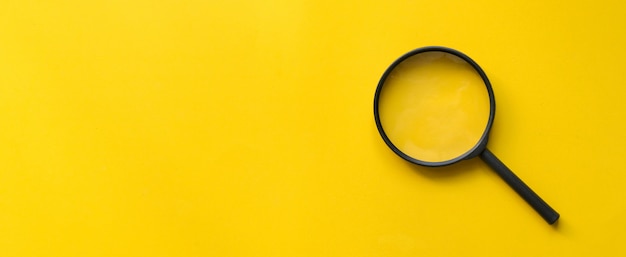 Foto close-up de vidro de lupa em fundo amarelo