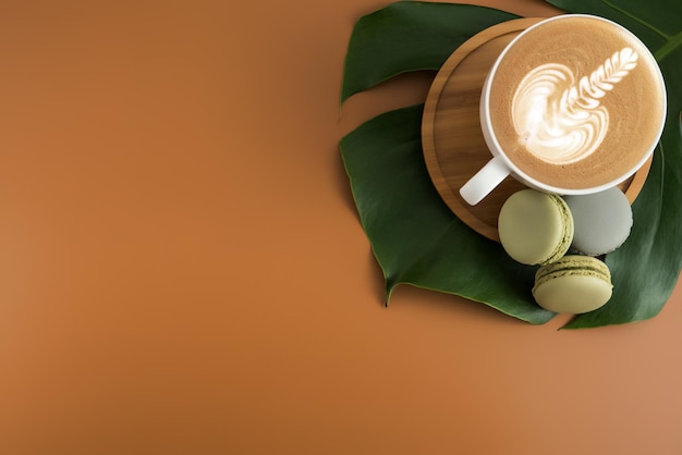 Close-up de xícara de café e macarrões em folha sobre fundo castanho